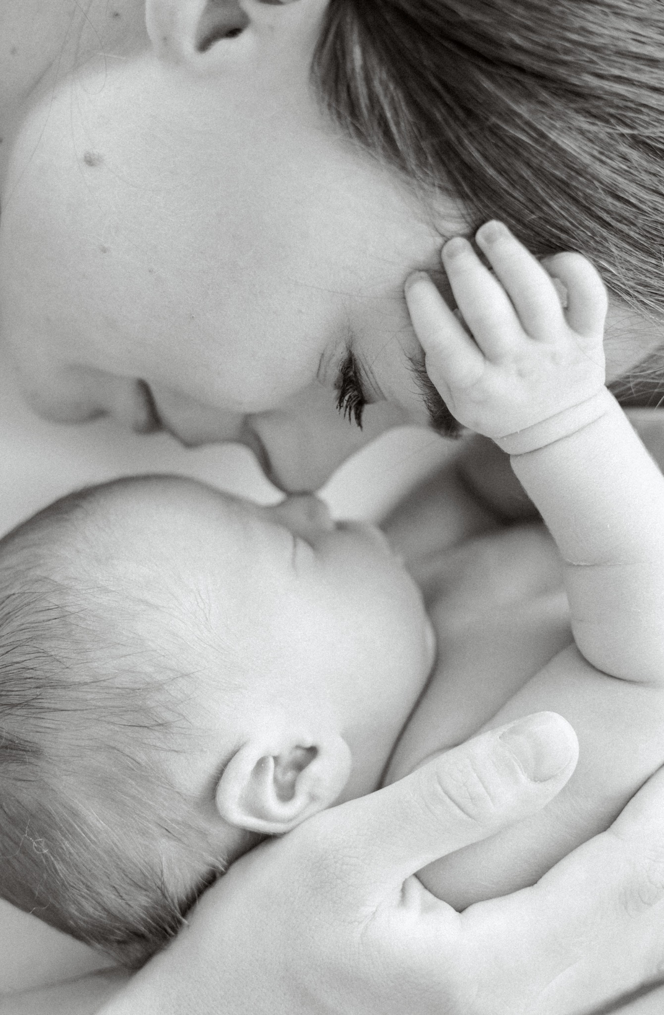 Bébé emmailloté paisiblement dans les bras de sa maman – Iryna Pinho Photography